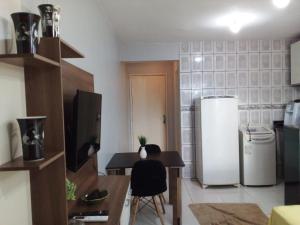 a kitchen with a small table and a refrigerator at Apto 348 centro nucleo bandeirante in Núcleo Bandeirante