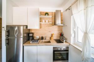 eine Küche mit weißen Schränken und einem Kühlschrank aus Edelstahl in der Unterkunft Villa Teuta in Korčula