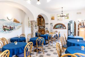 uma sala de jantar com mesas e cadeiras azuis em Hotel Casa Giuseppina em Ischia