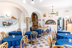 una sala da pranzo con tavoli e sedie blu di Hotel Casa Giuseppina a Ischia
