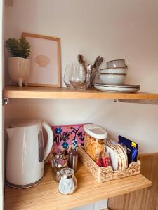 a shelf with food and other items on it at The Maiden Studio. Derry city. Studio Apartment. in Derry Londonderry
