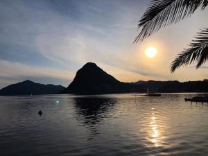 a large body of water with a mountain in the background at Bellevue- Bellavista in Castagnola +5 photos
