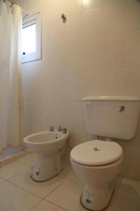 a white bathroom with a toilet and a sink at florinda casa orgánica in San Salvador de Jujuy