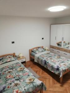 a bedroom with two beds and a mirror at Apartma Mi-Mari2 in Koper