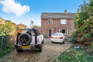 a white car parked in front of a house at Beautiful 5 Bedroom Free Parking Semi-Detached house Aylesbury in Buckinghamshire