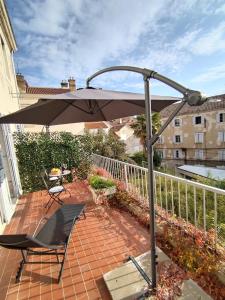een patio met een parasol en een tafel en stoelen bij Sunny terrace in Split