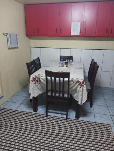 a table with four chairs and pink cabinets at Mishra Residence in Suva