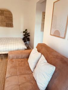uma sala de estar com um sofá castanho com duas almofadas em The Maiden Studio. Derry city. Studio Apartment. em Derry