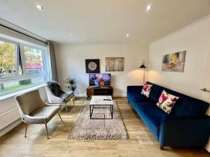 sala de estar con sofá azul y mesa en Home2 Home - Market Rise en Cambridge