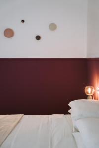 a bedroom with a white bed and a burgundy wall at Casa Camilla in San Michele allʼAdige