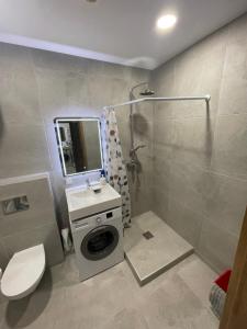 a bathroom with a shower and a washing machine at Airport Apartment 25 Self Check-In Fee Parking in Vilnius