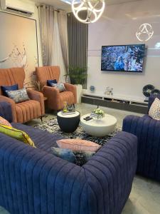 a living room with a large blue couch at The King's Landing Apartments in Maiyegun