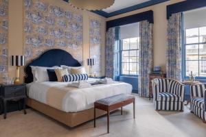エディンバラにあるEleven Stafford Street Townhouseの青い壁のベッドルーム1室(キングサイズベッド1台付)