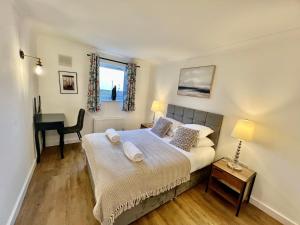 Schlafzimmer mit einem Bett, einem Schreibtisch und einem Fenster in der Unterkunft Home2 Home - Market Rise in Cambridge