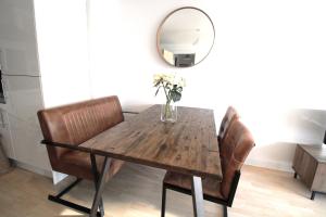 a dining room table with chairs and a mirror at The Elm @ Short Stays in Basingstoke +3 photos