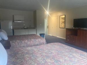 Una habitación de hotel con dos camas y un televisor de pantalla plana. en Travelodge by Wyndham Canyonville, en Canyonville
