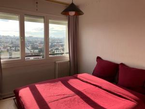 - une chambre avec un lit rouge et une grande fenêtre dans l'établissement Kastel, à Maisons-Alfort