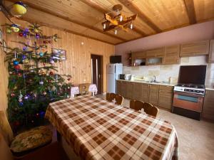 a kitchen with a table and a christmas tree at Barvinok Karpat in Yaremche