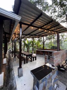 a pavilion with a picnic table and a grill at Finca Mi Carmencita in Mocoa