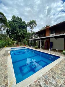 a swimming pool in front of a house at Finca Mi Carmencita in Mocoa