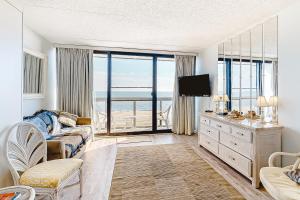 a living room with a couch and a television with a view at Golden Sands 605 in Ocean City