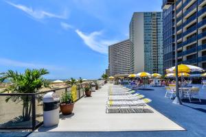 大洋城的住宿－Golden Sands 605，海滩上的一排躺椅和遮阳伞