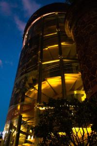 a glass building with lights on it at night at Ikonik Hotel Puebla in Puebla