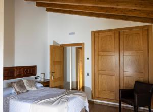 a bedroom with a bed and a wooden cabinet at La Tahona in Fermoselle