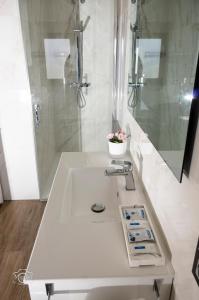 a white bathroom with a sink and a shower at La Tahona in Fermoselle