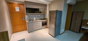 a kitchen with a stainless steel refrigerator and cabinets at Flat de luxo no Jade Park Sul Brasília-DF in Brasilia