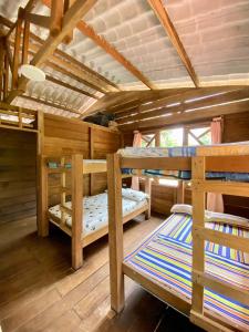 a room with three bunk beds in a cabin at Finca Mi Carmencita in Mocoa
