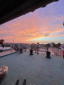 un balcone con vista sull'oceano al tramonto di Dinosaur Anza Surf House ad Agadir