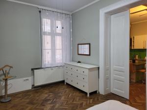 a white bedroom with a dresser and a window at Condor in Arad
