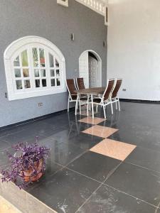 a dining room with a table and chairs on a tile floor at The Manor in Lomé