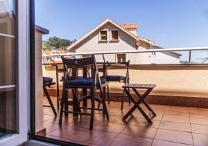 een tafel en stoelen op een balkon met een huis bij Apartamento Playa Blanca in Corcubión