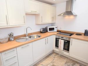 kuchnia z białymi szafkami i zlewem w obiekcie 1 bed property in Shaftesbury 46774 w mieście Bourton