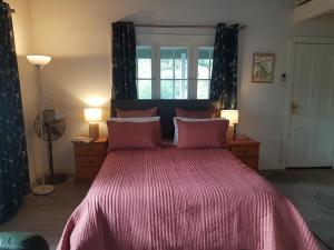 a bedroom with a large bed with a pink comforter at Brookvale House Balingup in Balingup