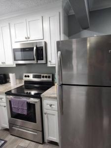 cocina con nevera de acero inoxidable y microondas en Blue Shark *H14* @ Montrose Elegant 1BR King Apartment, en Houston