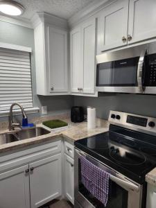 cocina con armarios blancos y fogones en Blue Shark *H14* @ Montrose Elegant 1BR King Apartment, en Houston