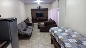 uma sala de estar com um sofá e uma televisão em Casa Rota das 3 Fronteiras em Foz do Iguaçu