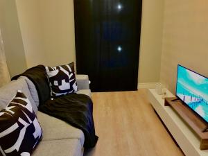 sala de estar con sofá y TV de pantalla plana en Apartment in Sandton, Rivonia en Johannesburgo