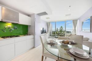 a kitchen and dining room with a table and chairs at Belle Escapes - Bay View Lookout With Sea Views in Glenelg