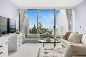 a living room with a couch and a table at Belle Escapes - Bay View Lookout With Sea Views in Glenelg