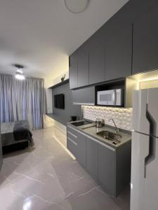 una cocina con fregadero y una cama en una habitación en GRAY ONE - Apto novo, moderno, varanda, poucos passos da estação Luz, en São Paulo