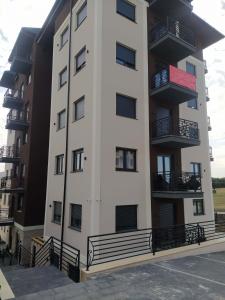 Un edificio de apartamentos con balcones y estacionamiento. en Centar Sveta, en Zlatibor