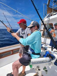 two men fishing on a boat in the ocean at Mantarraya in Puerto Baquerizo Moreno
