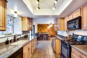 a kitchen with wooden cabinets and a stove top oven at Laughlin Retreat with Pool 2 Mi to Big Bend! in Laughlin