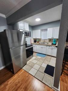 a kitchen with a stainless steel refrigerator and white cabinets at Blue Shark *H21* @ Montrose 1BR Tranquil King Apartment in Houston +25 photos
