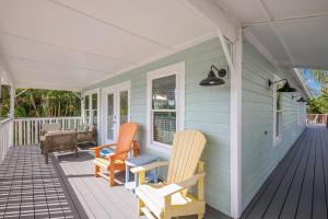 a porch with two chairs on a house at Canario Cottage Home in Anna Maria