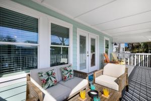 a porch with a couch and chairs on it at Canario Cottage Home in Anna Maria
